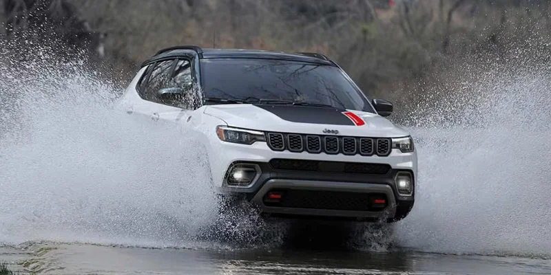 Jeep Compass driving through water, showcasing its off-road capabilities.