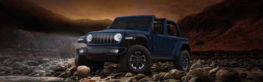 Blue Jeep Gladiator Rubicon off-roading on rocky terrain at sunset